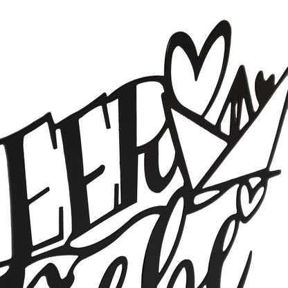 Detailansicht des schwarzen Metall-Schriftzugs „Meer Liebe“ mit Herz und Papierboot, Teil eines Deko-Aufstellers auf Holzsockel.